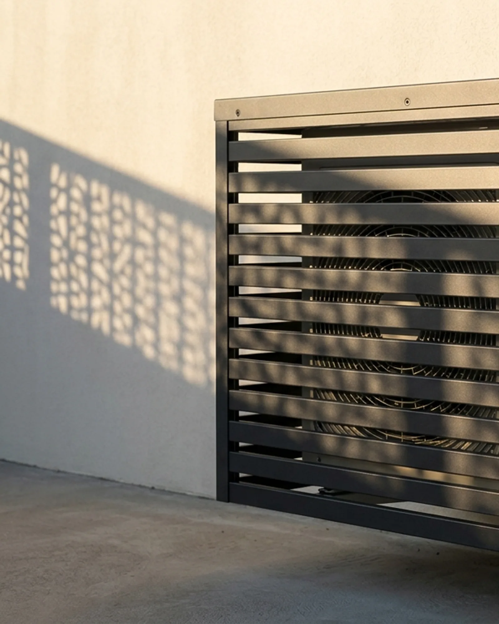 Slatted aluminium air conditioner cover mounted on an exterior wall with the condenser visible behind