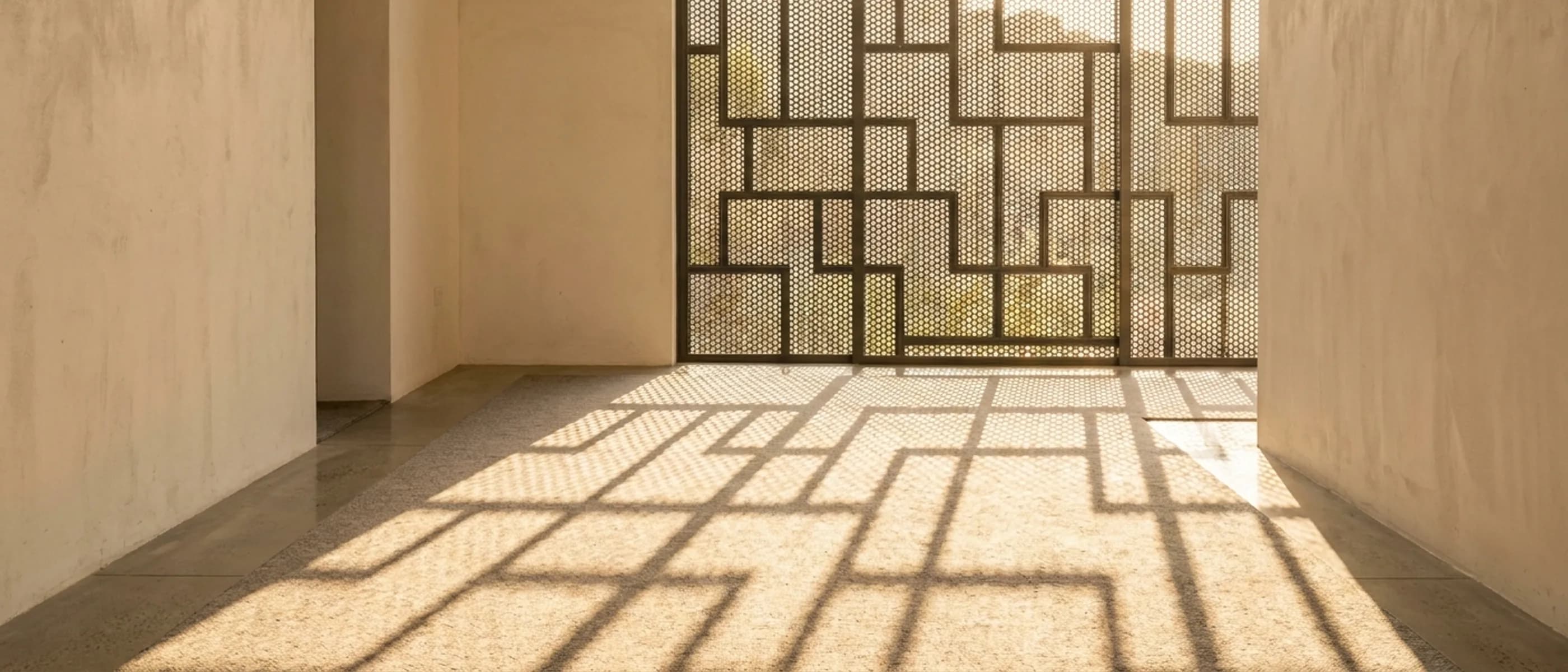 Interlocking geometric aluminium screen in a mosque interior with light falling through the apertures