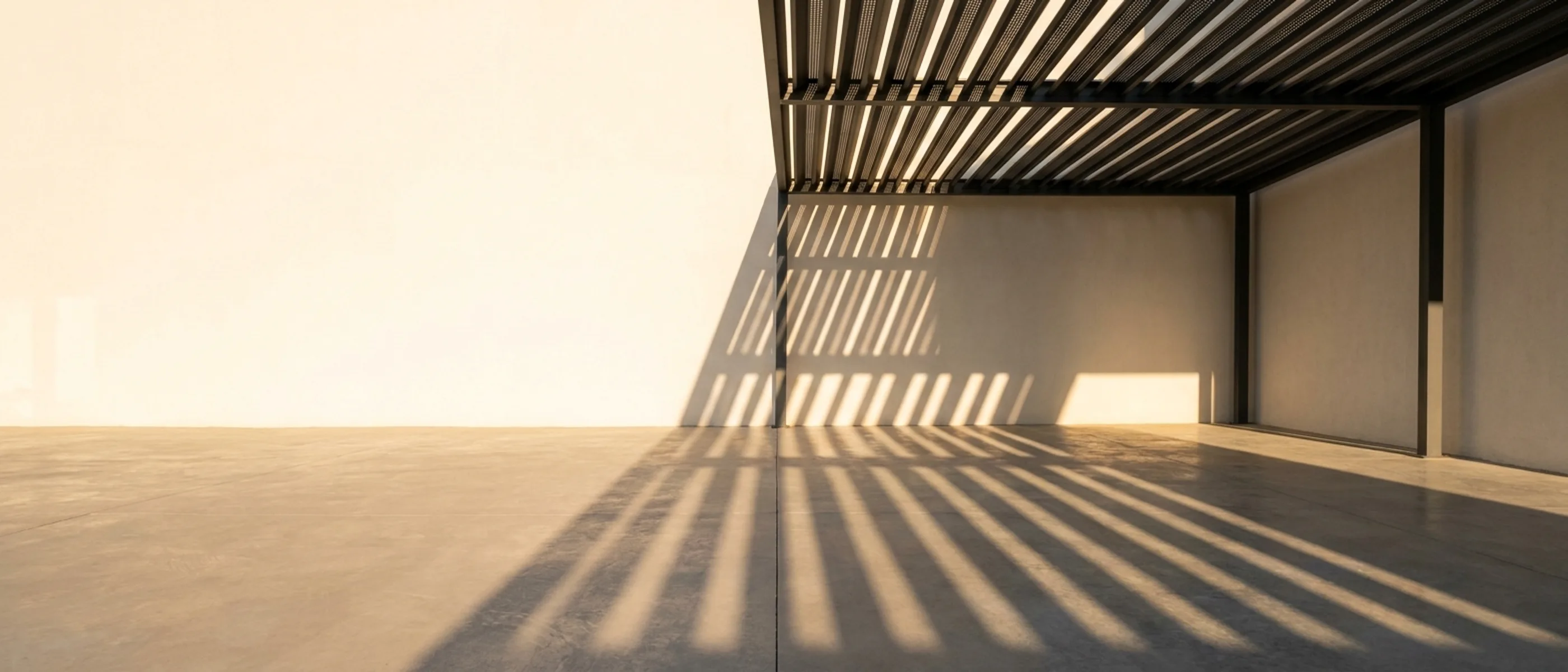 Aluminium louvre pergola throwing striped shade across a paved terrace